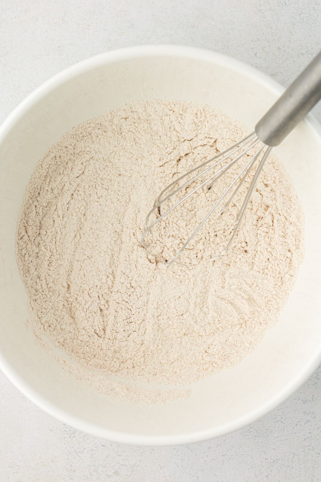 bowl of flour with a whisk