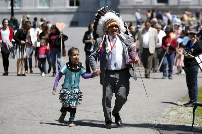 Assembly of First Nations National Chief Perry Bellegarde runs with a school girl to place a heart shaped card in the Heart Garden, which is meant to symbolize reconciliation, during the Truth and Reconciliation Commission of Canada closing ceremony at Rideau Hall in Ottawa June 3, 2015.    REUTERS/Blair Gable