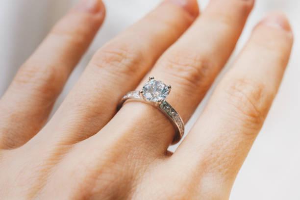 Close up of a woman hand with a diamond ring Close up of a woman hand with a diamond ring diamond ring stock pictures, royalty-free photos & images