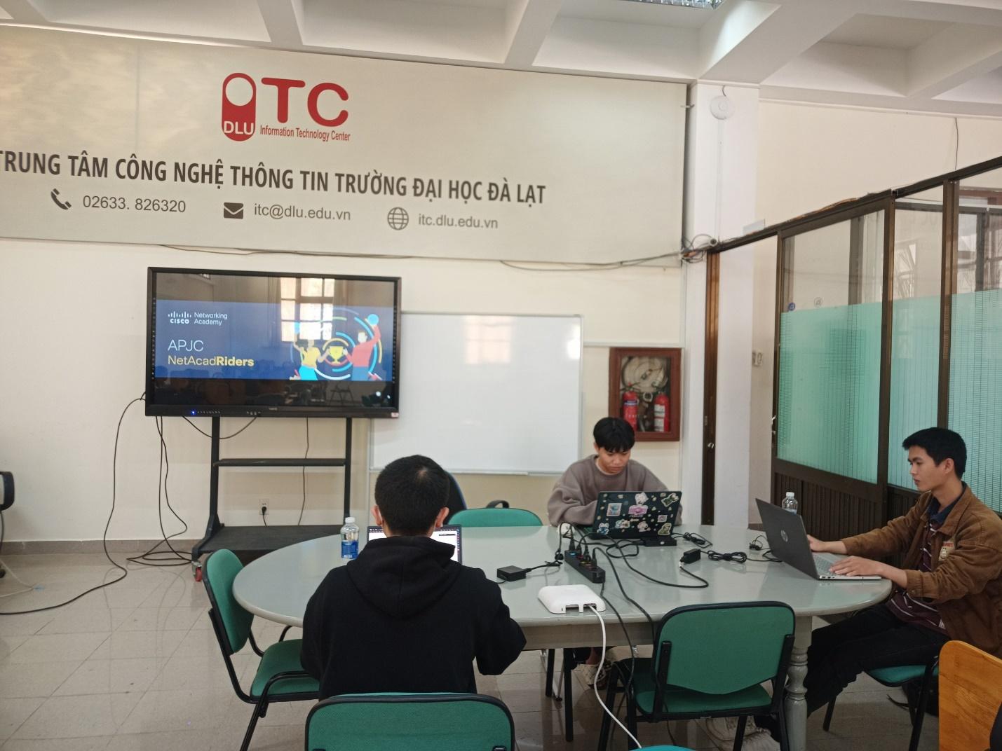 A group of people sitting at a table with laptops

Description automatically generated