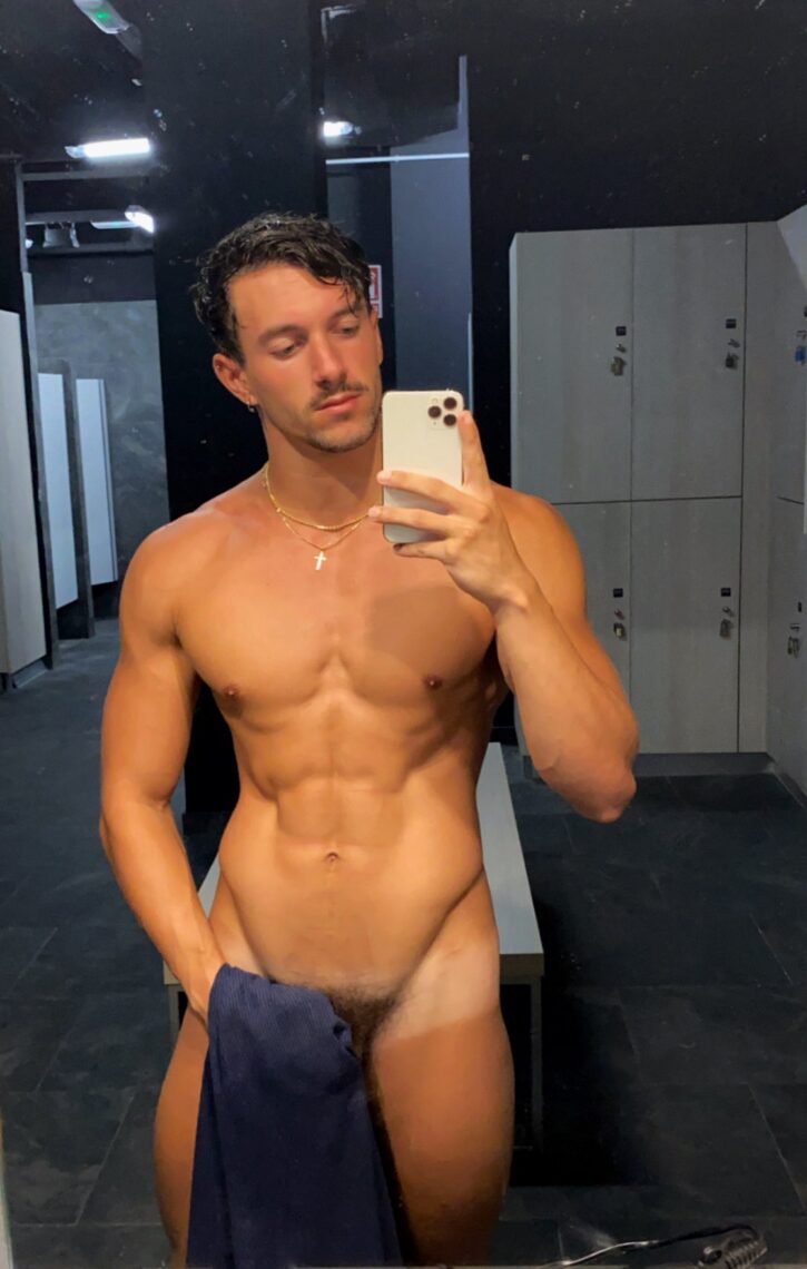 Eric Rmgr taking a naked gym mirror selfie covering his crotch with blue navy towel