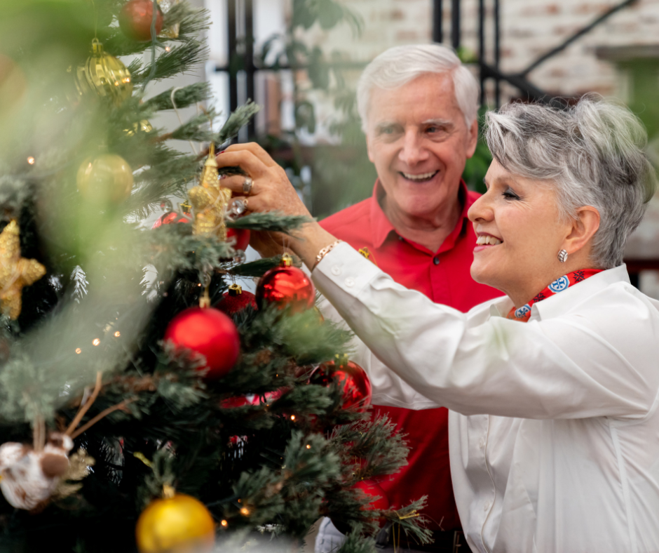 An older couple decorating a christmas tree