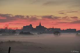 A foggy landscape with buildings and trees

Description automatically generated