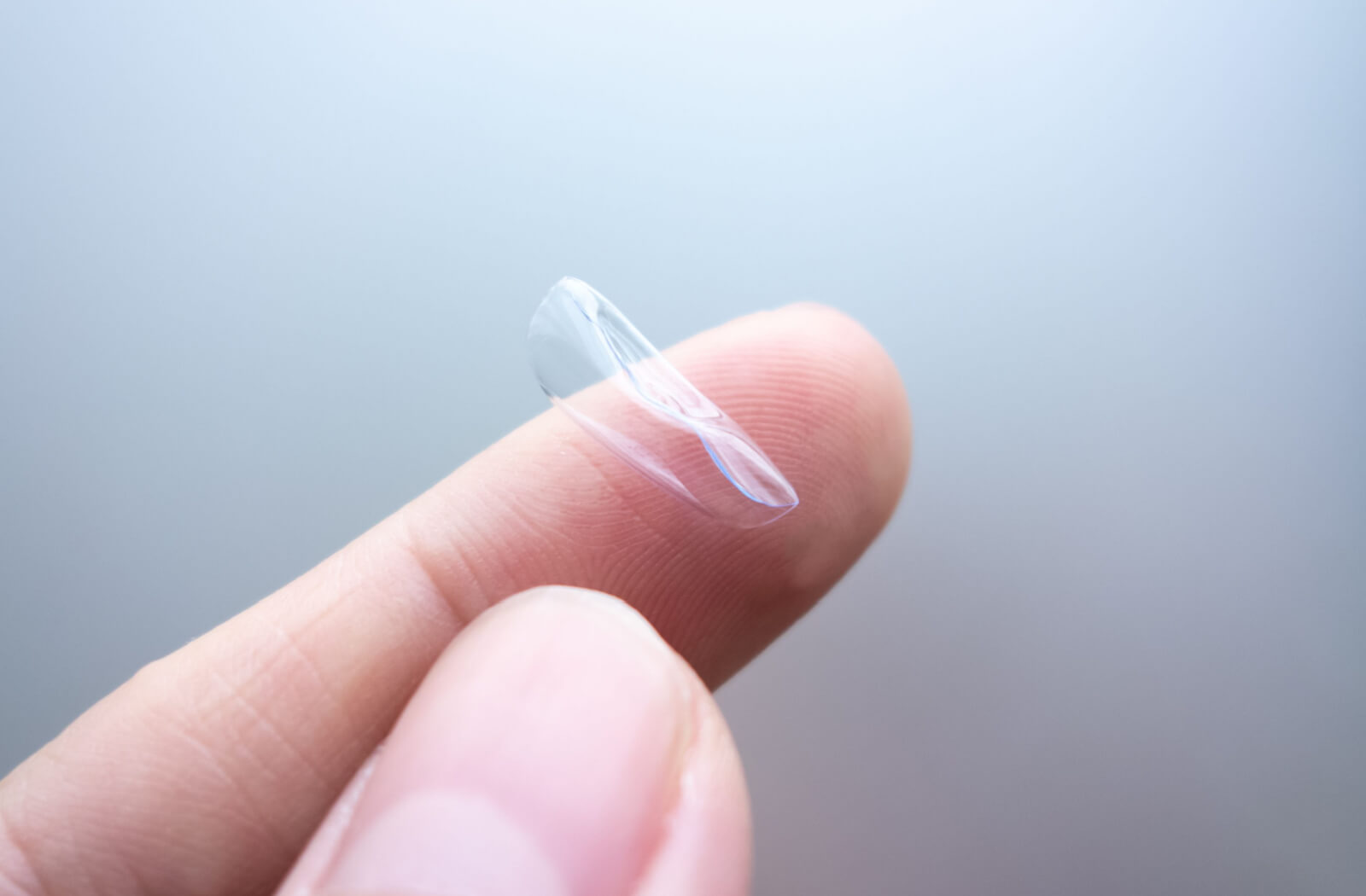 A warped contact lens on a person's finger.