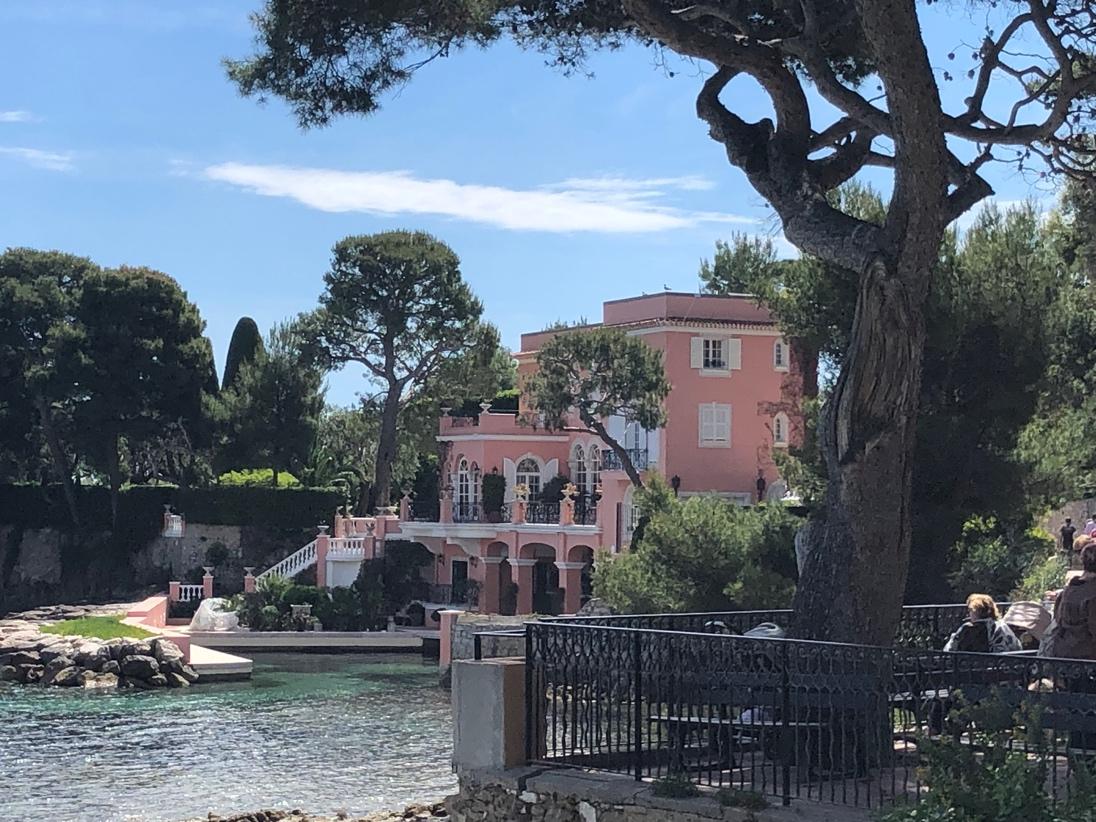 A pink building next to a body of water

Description automatically generated