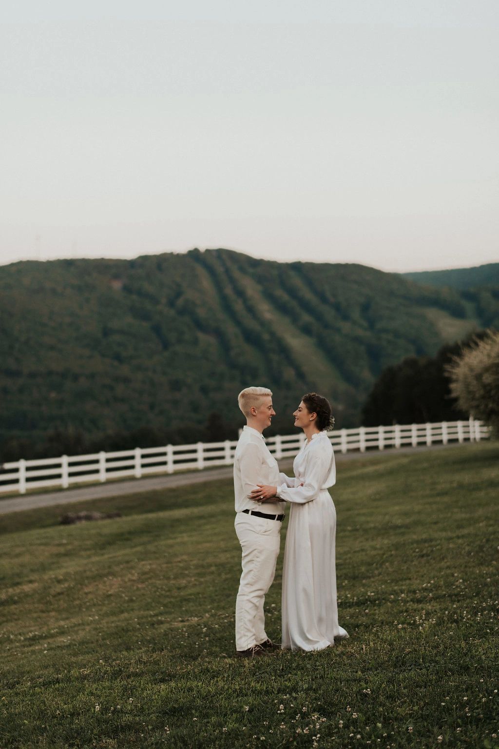 Couple standing together in field holding each other