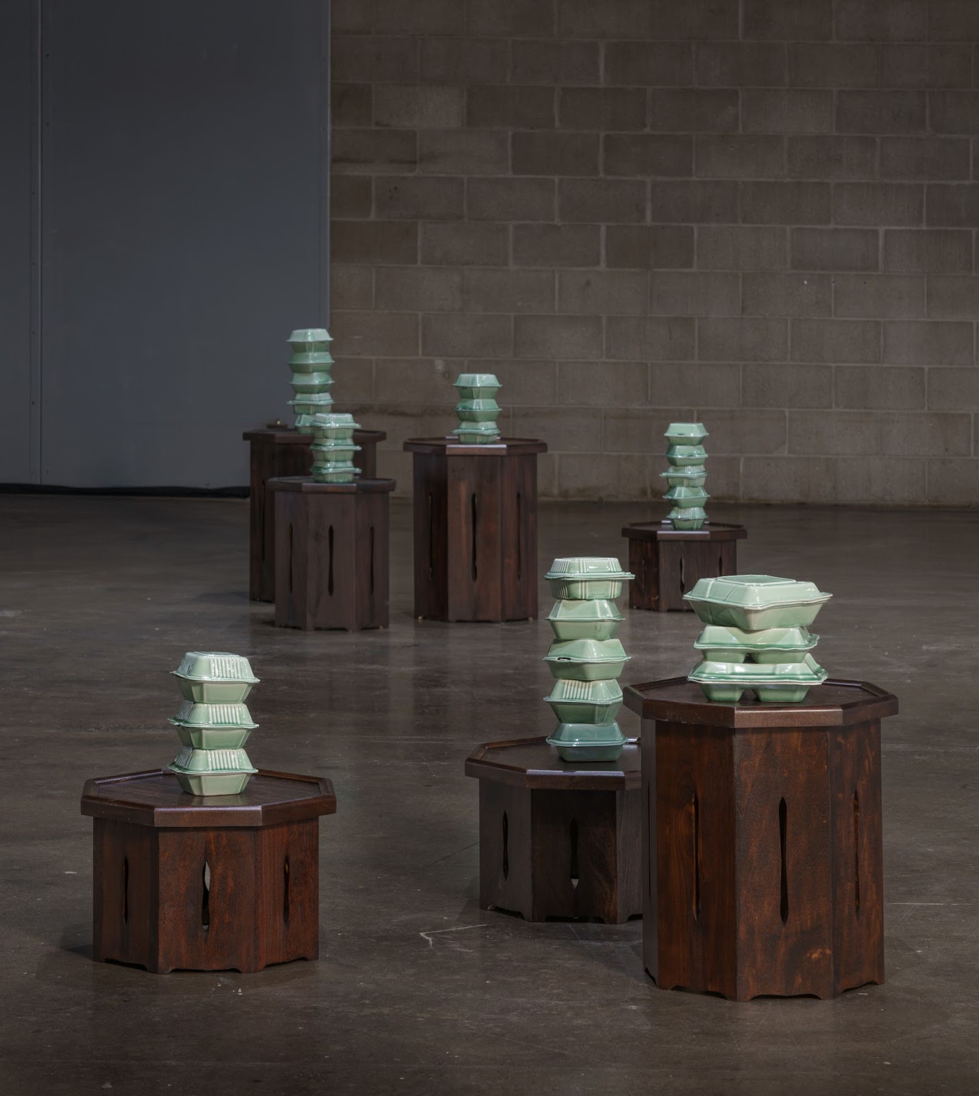 Image: Installation view, Yoonmi Nam, Generally Meant to be Discarded. Slip cast exteriors from the Cairn series are displayed on the soban pedestals. Image courtesy of the artist, photo by E.G. Schempf