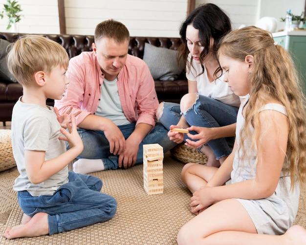 Free photo family playing jenga in living room