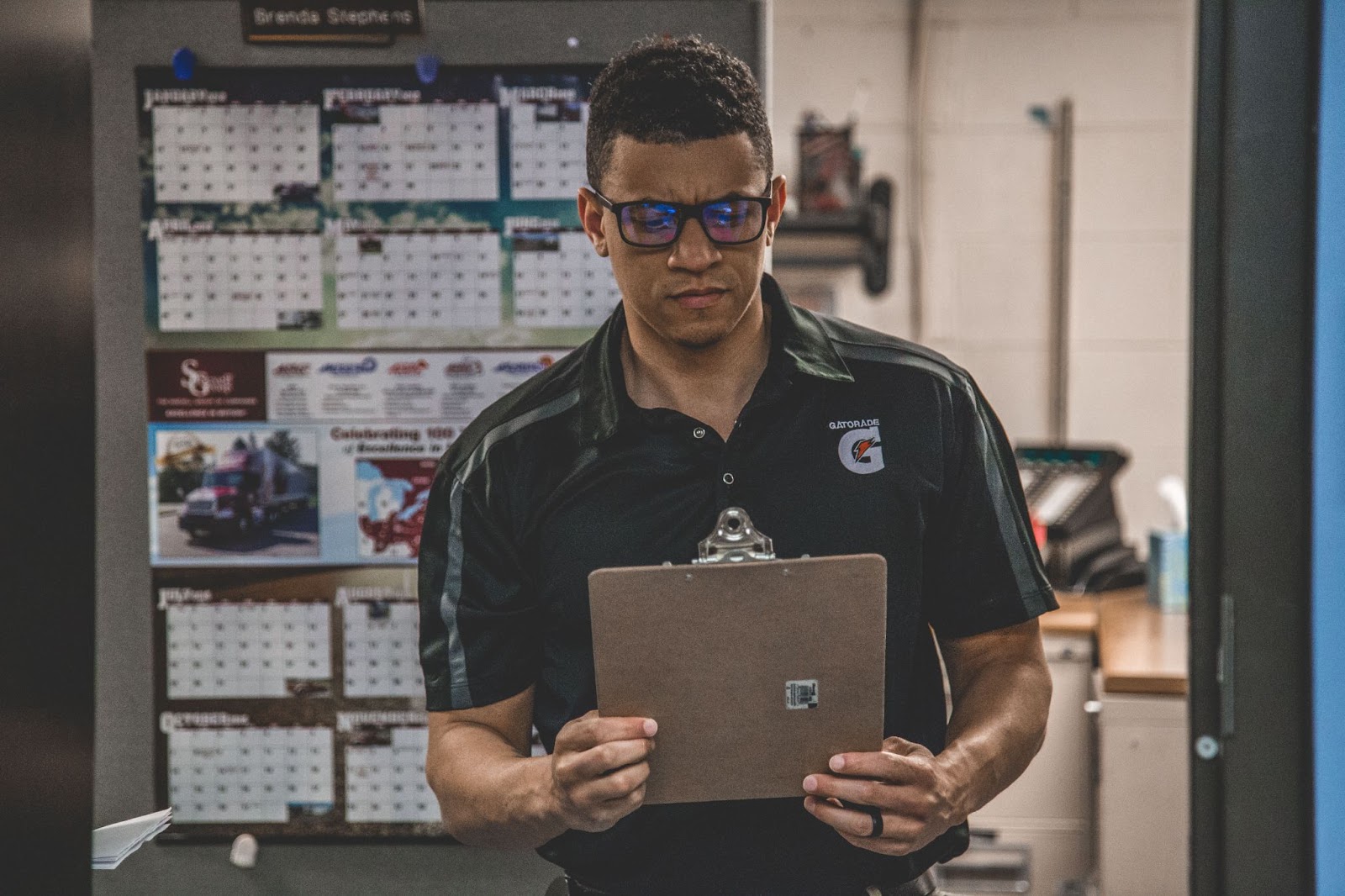 A man staring down at a clipboard inside of an office