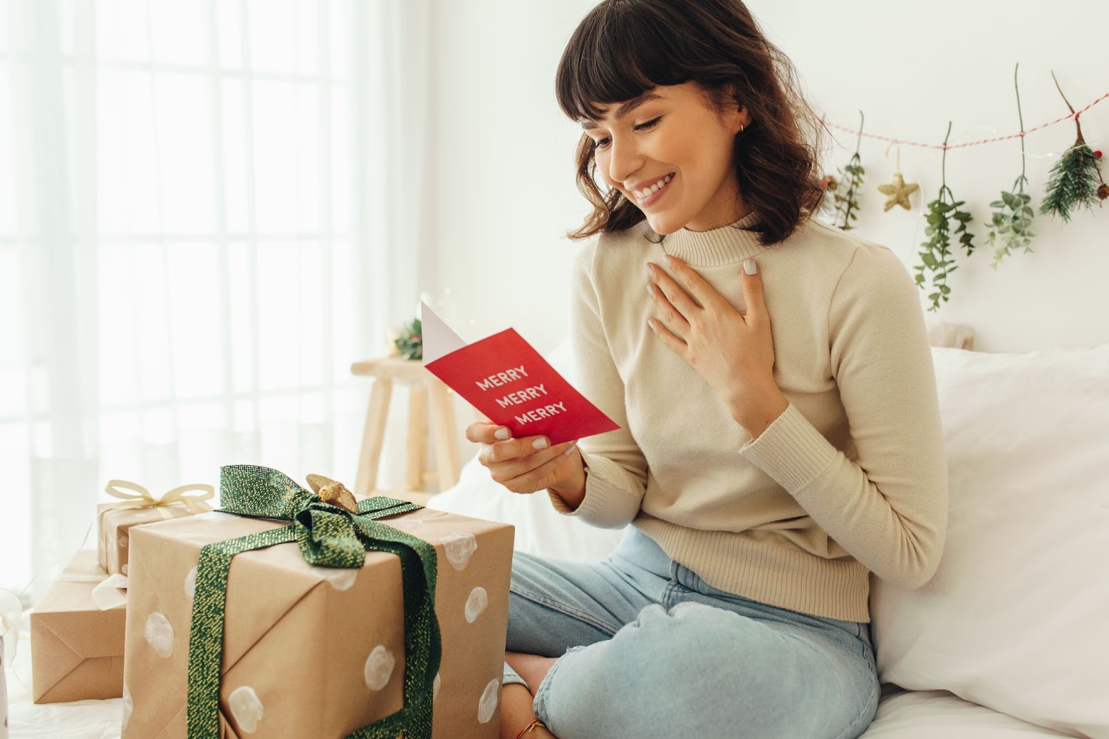 A woman reading a Christmas card that says “Merry Merry Merry”