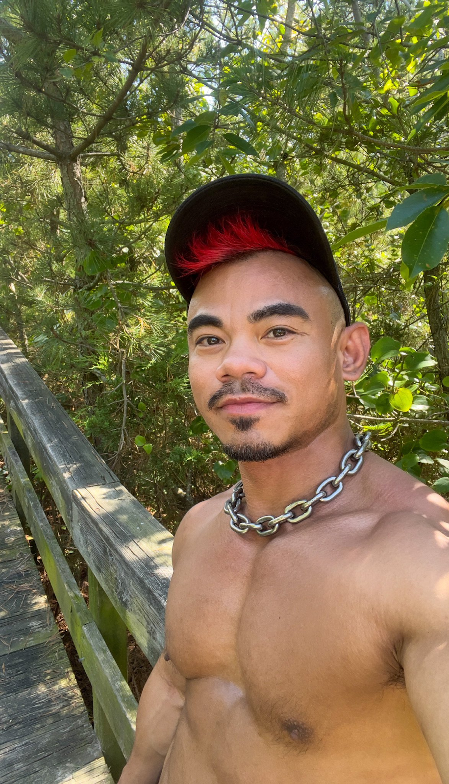 gay xxx porn actor Jason Luna gay cruising at outdoor gay cruising parks shirtless wearing heavy chain necklace and black baseball hat smiling while taking a selfie