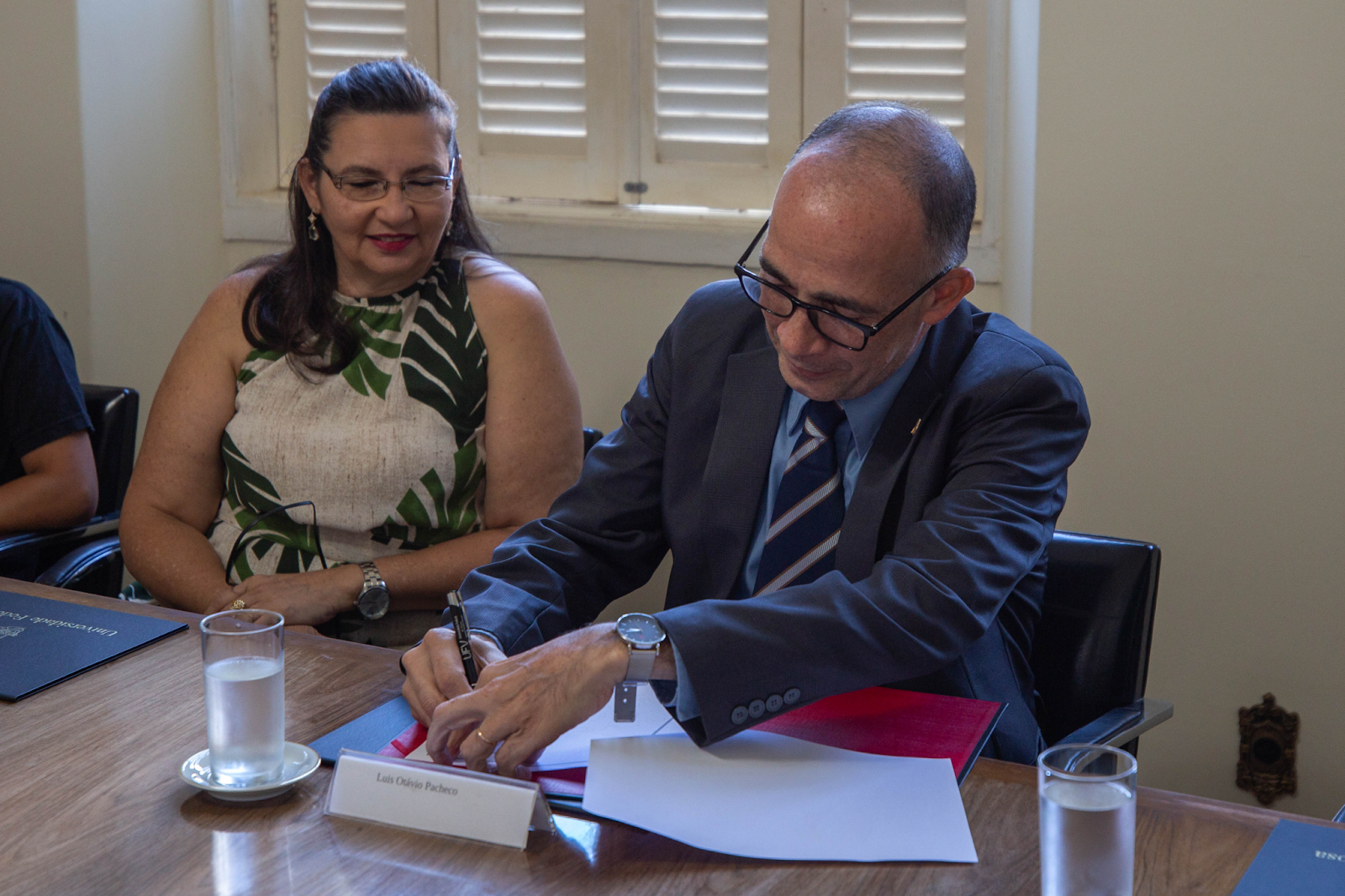 Foto oficial do novo auditor-chefe assinando papeis de sua posse.