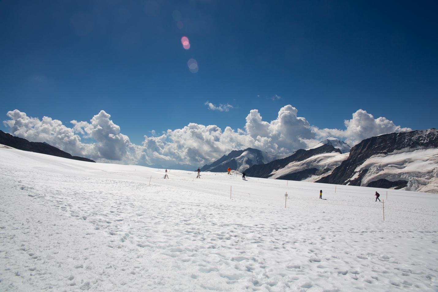 A snow covered mountain with people skiing

Description automatically generated