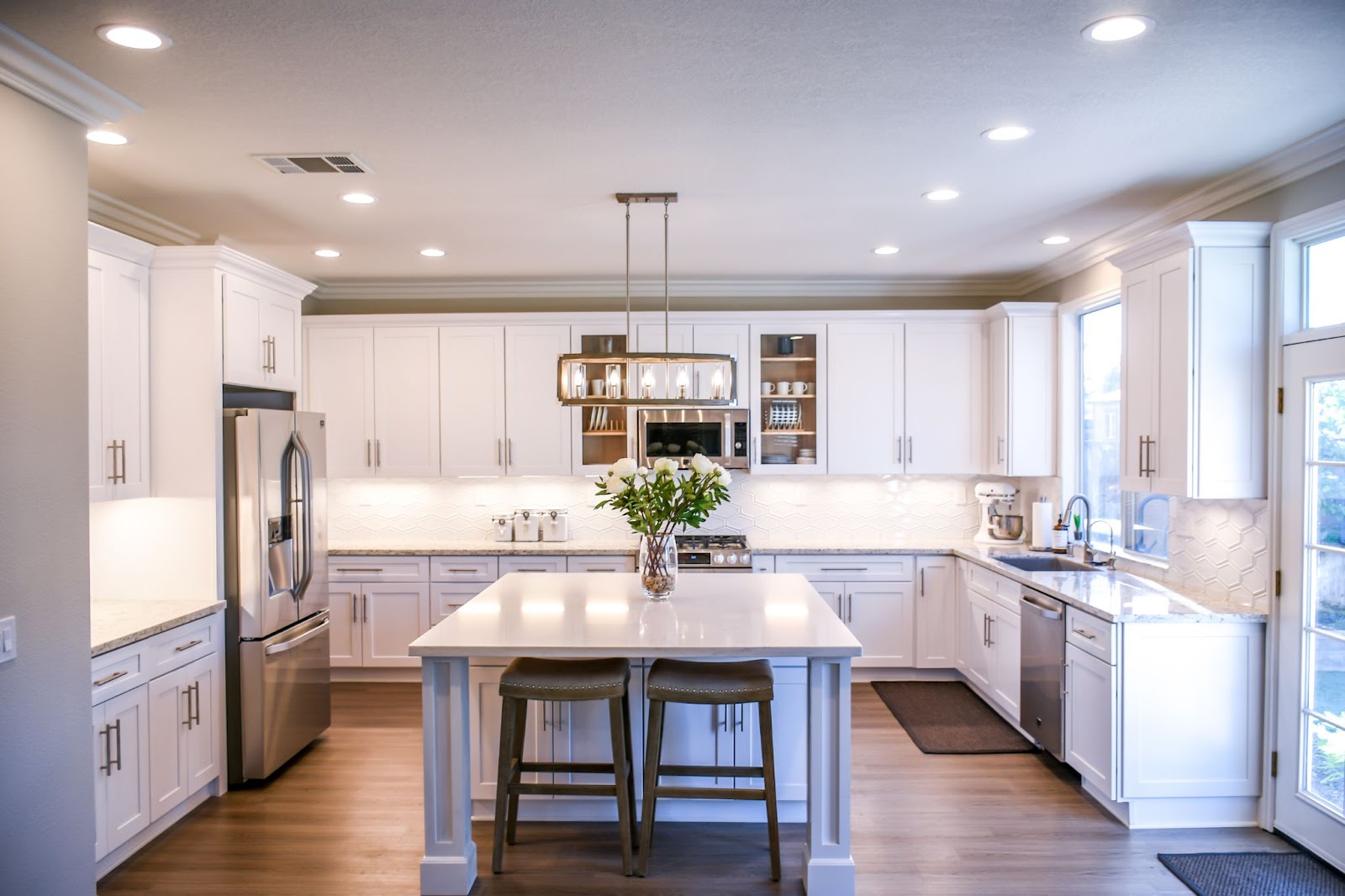 A luxurious white kitchen with soft lighting