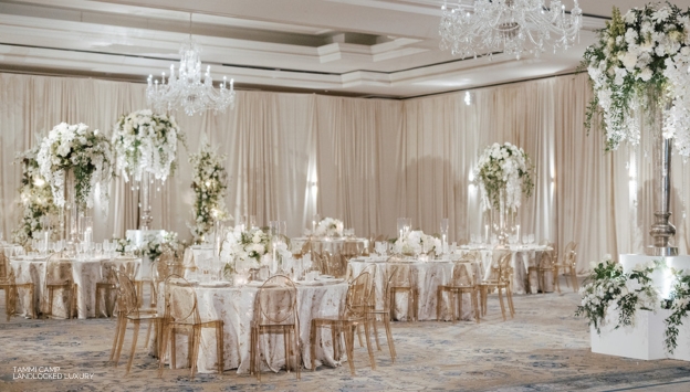 Beautiful white and gold indoor wedding venue with green flowers
