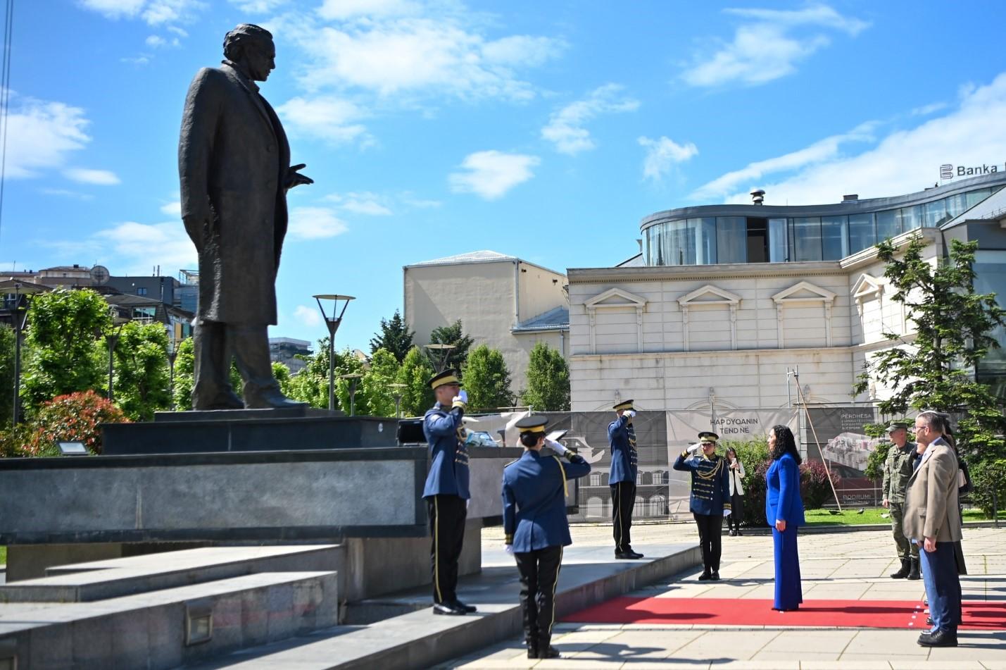 A group of people standing in front of a statue Description automatically generated