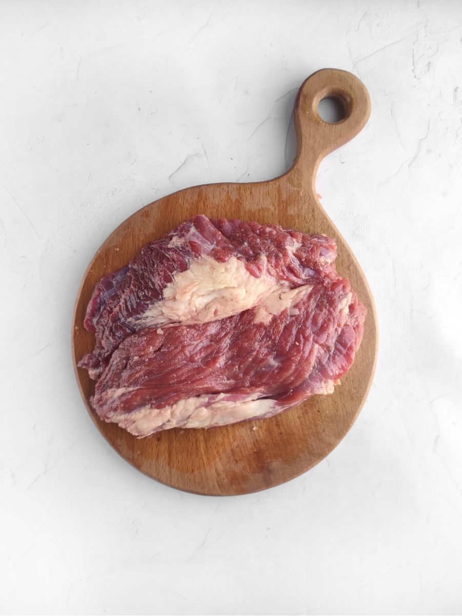 An air-fried ribeye steak on a wooden cutting board.