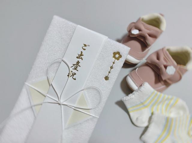 出産祝いの祝儀と幼児用の靴と靴下の写真