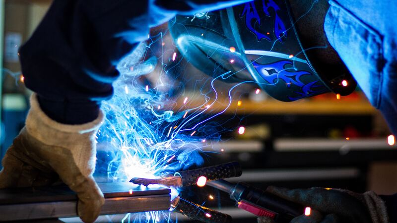 An expert welder, monitoring and welding the workpieces. 