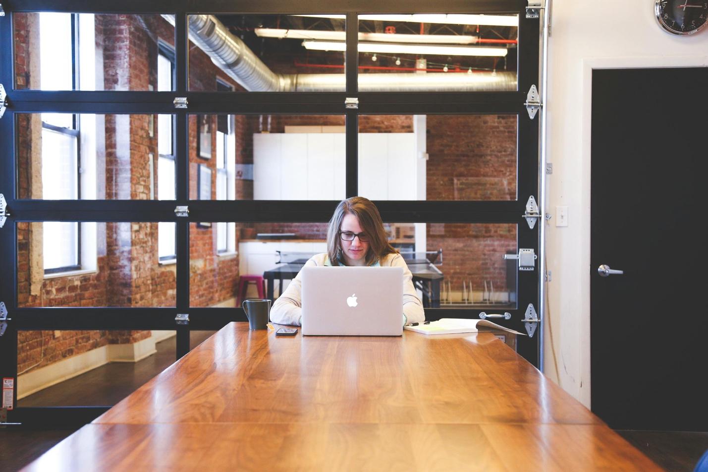 A person sitting at a table with a computer

Description automatically generated