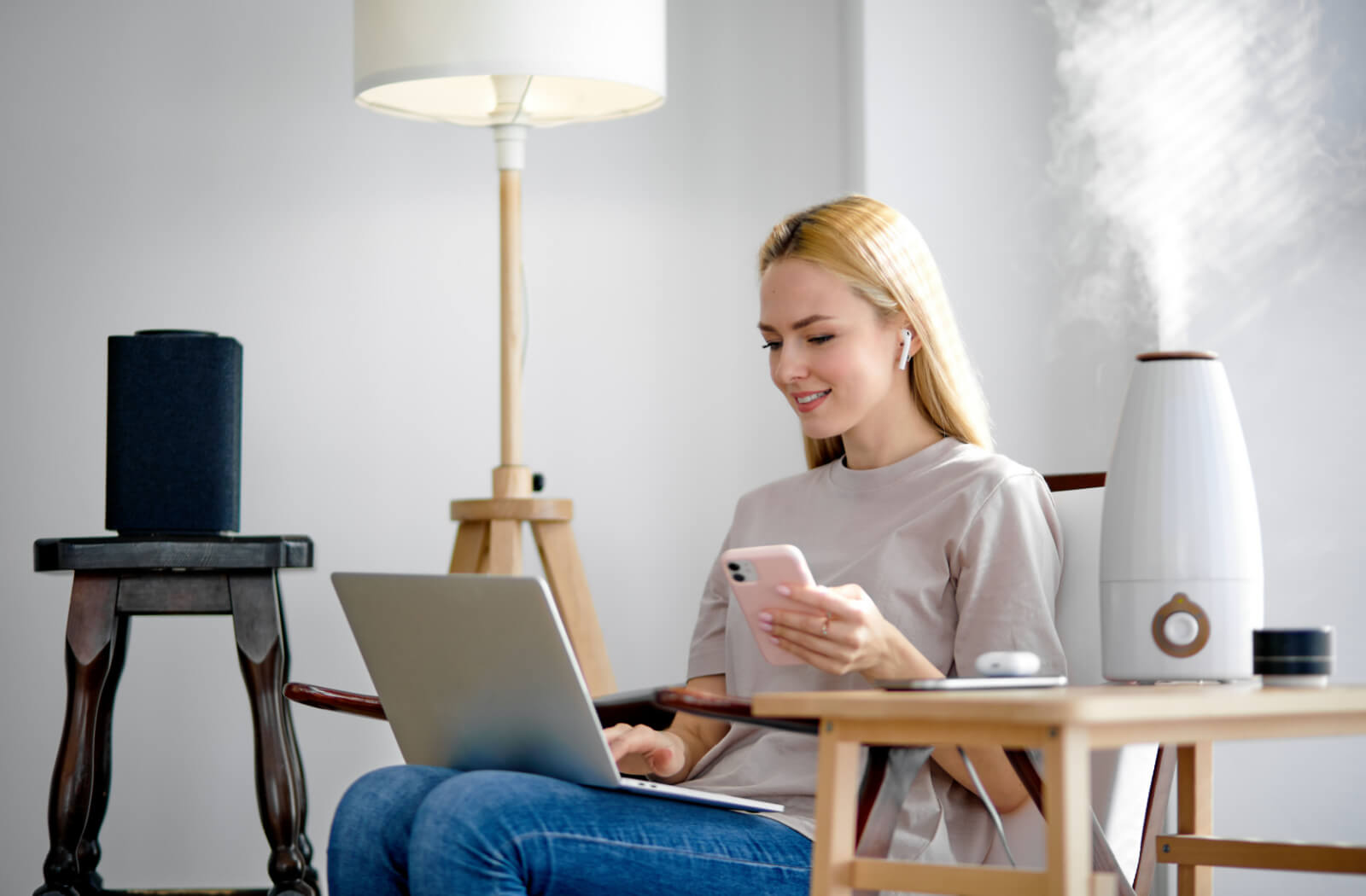 A woman using her laptop beside a humidifier to alleviate dry eye symptoms.