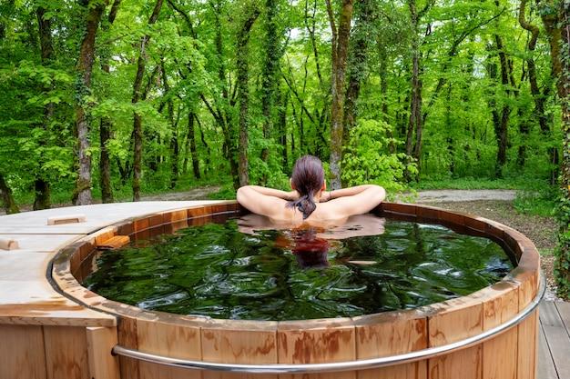 Free photo woman in nordic bath in front of a forest