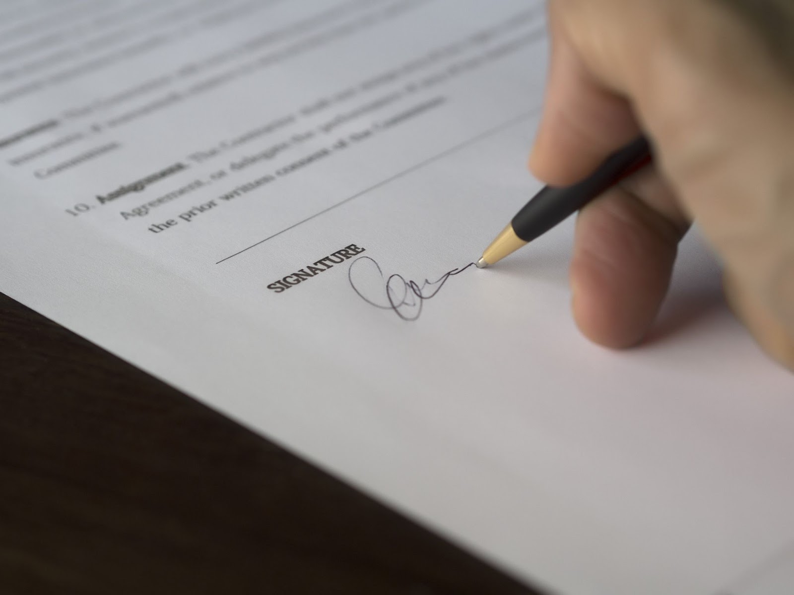 this close up image is of someone signing a document
