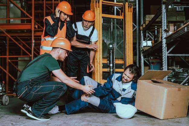 Photo young warehouse worker injured leg at workplace