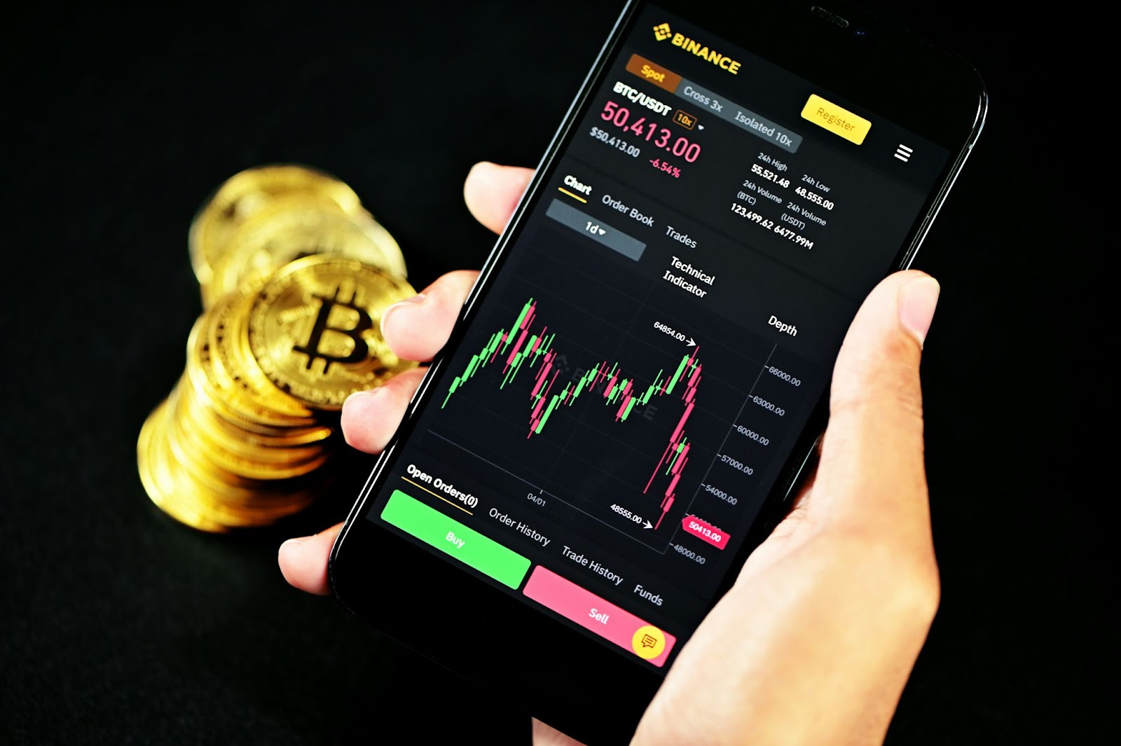 Hand holding phone with crypto trading app, caution advised against forex trading scams