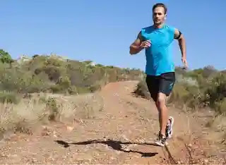 A man running on a desert dirt road, exemplifying one of the fitness habits that may harm the body before turning 50.