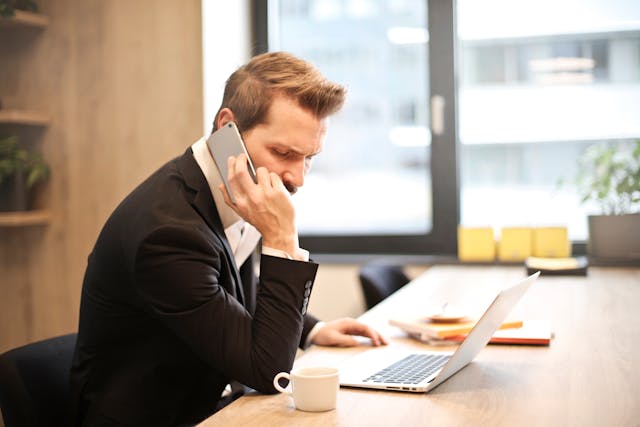 A person in a suit on a phone call.