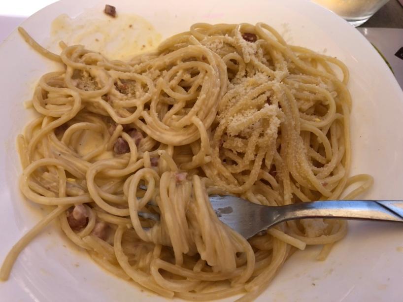 A plate of spaghetti with a fork

Description automatically generated