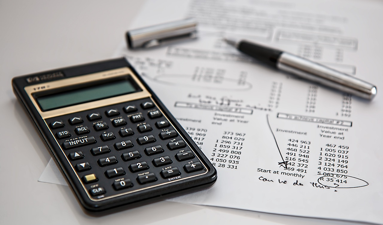 Calculator, pen and balance sheet