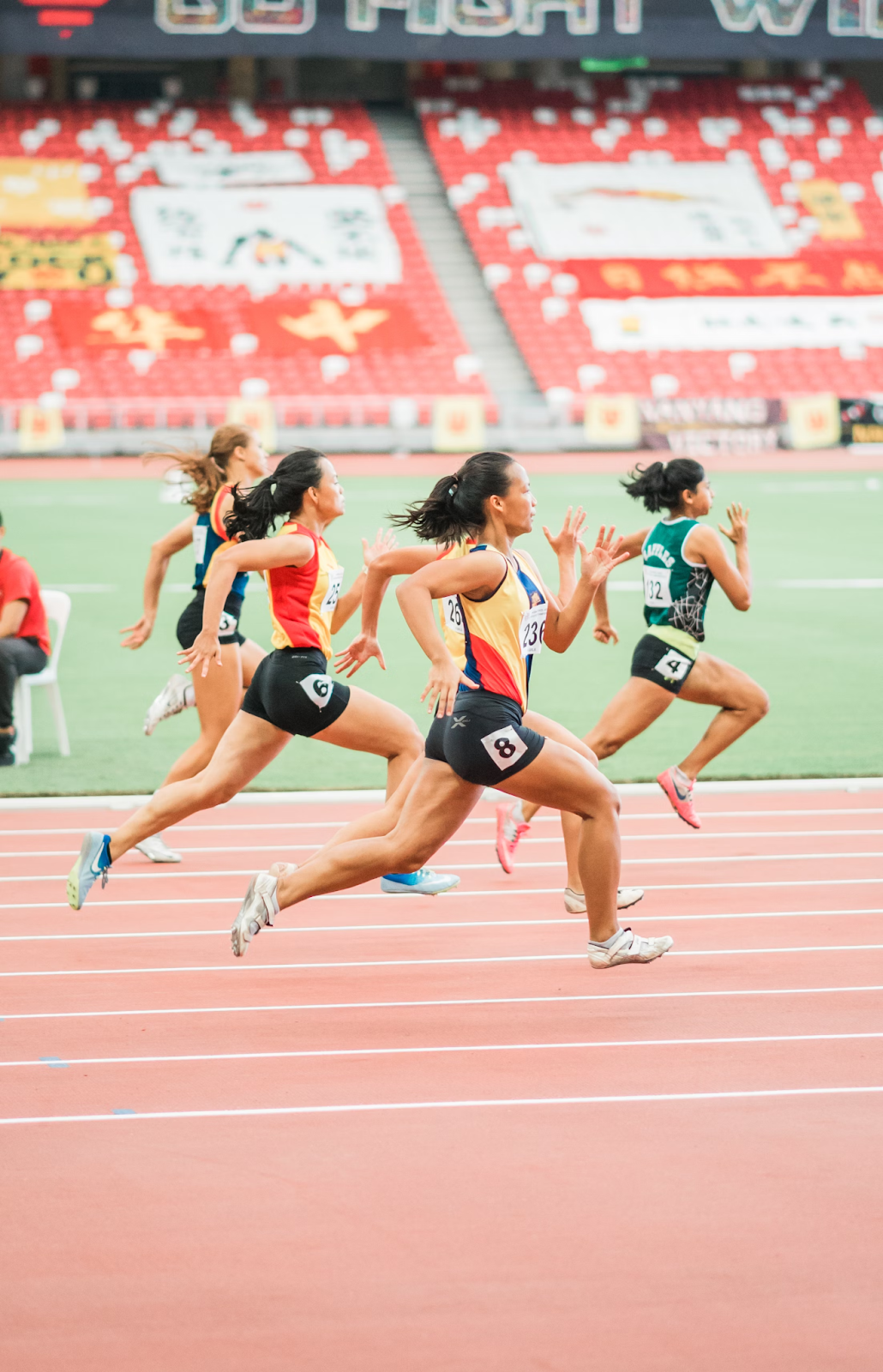 Female athletes running on track.