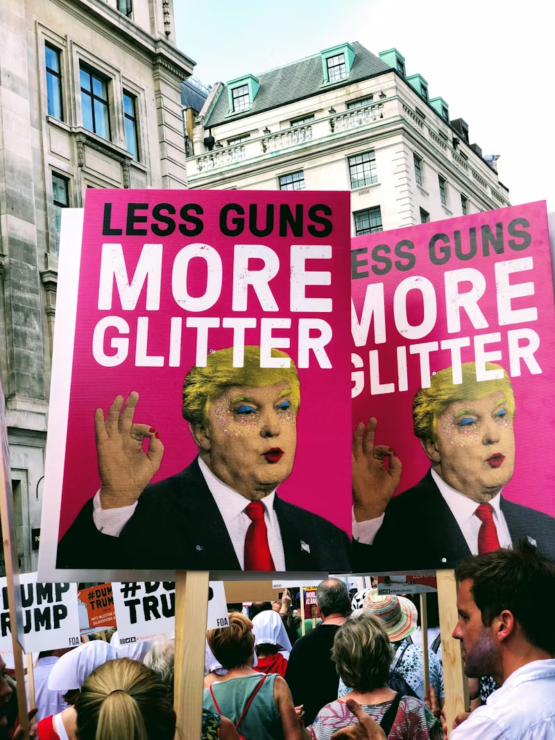 People protesting with "Less guns more glitter" sign