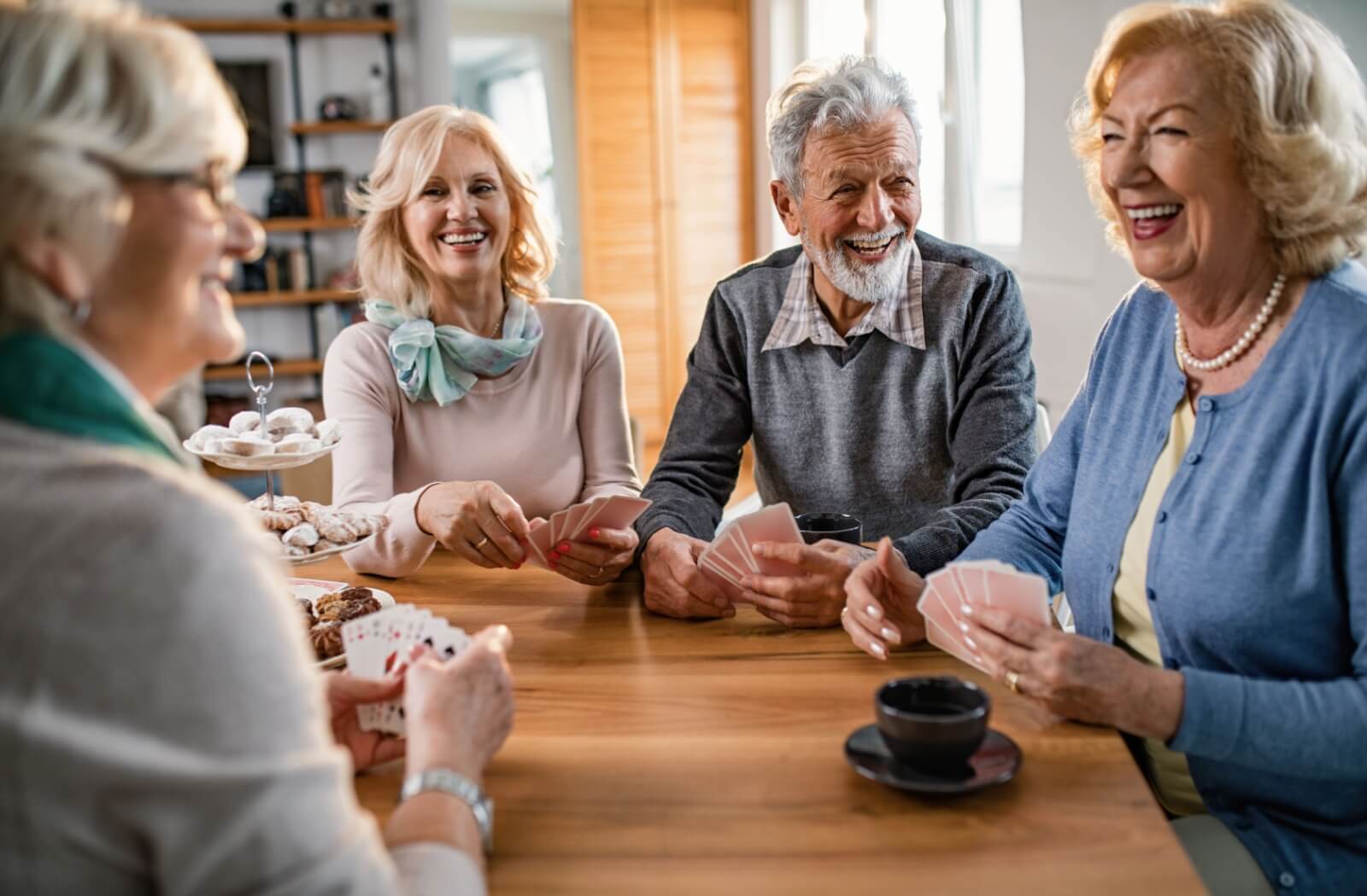 A group of happy older adults playing cards together.