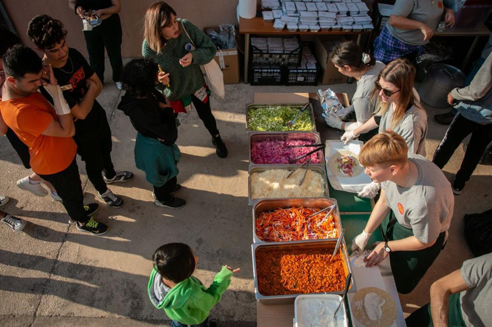 Workers serve food at the Saffron Kitchen Project in Athens