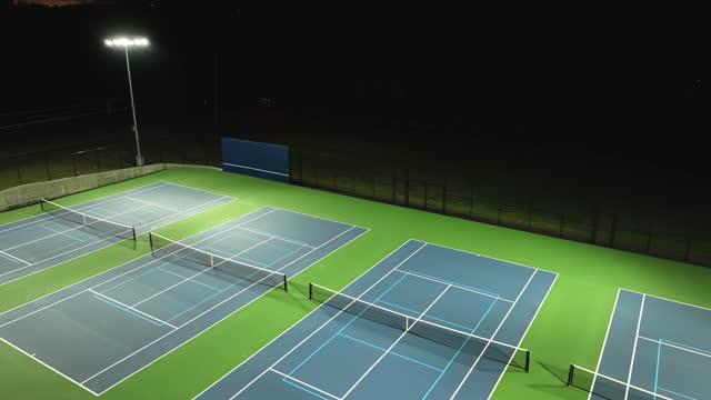 LED lights illuminating a tennis court at night, provided by Stouch Lighting