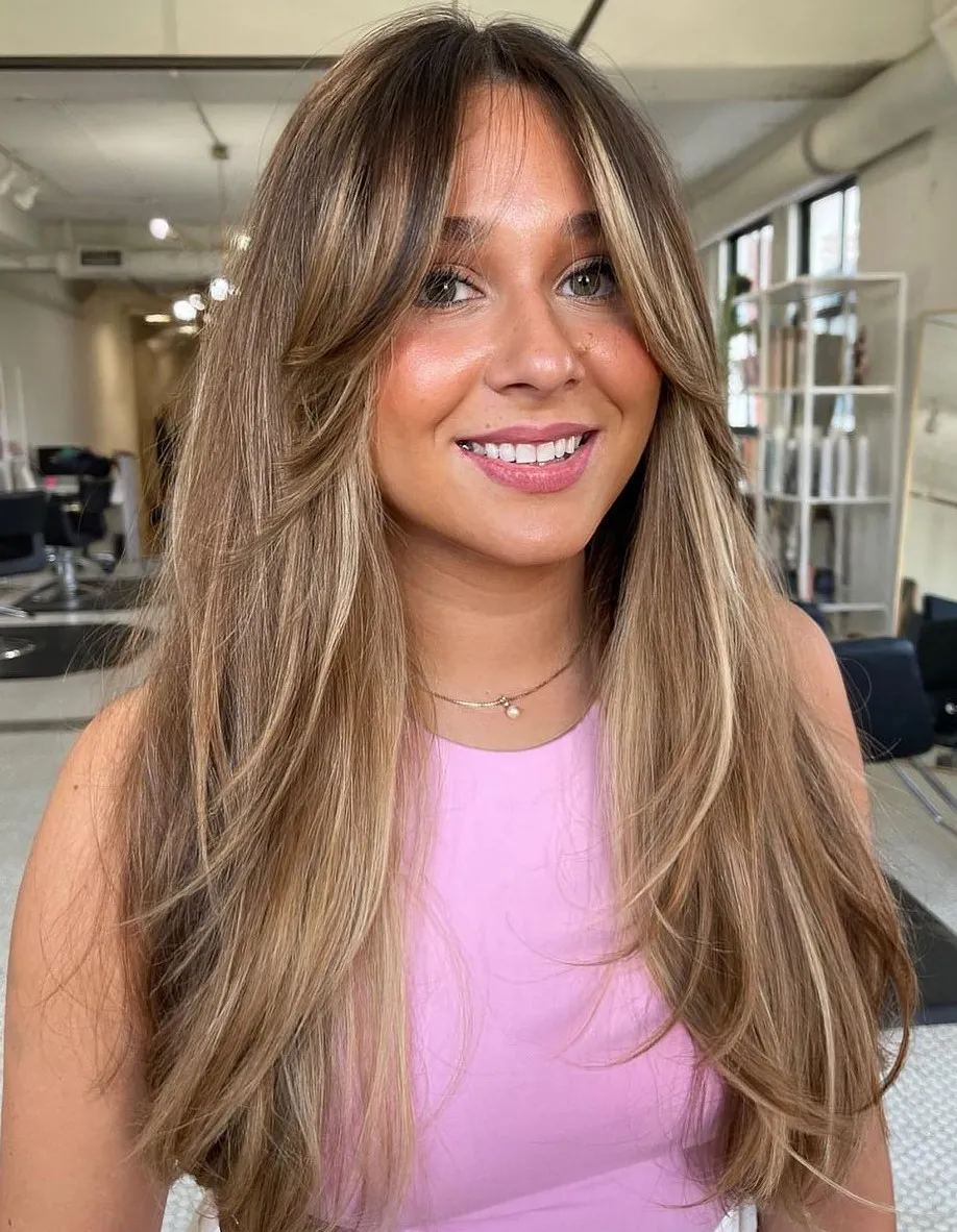 Picture of a lady wearing Sun-Kissed Balayage and Soft Curtain Bangs