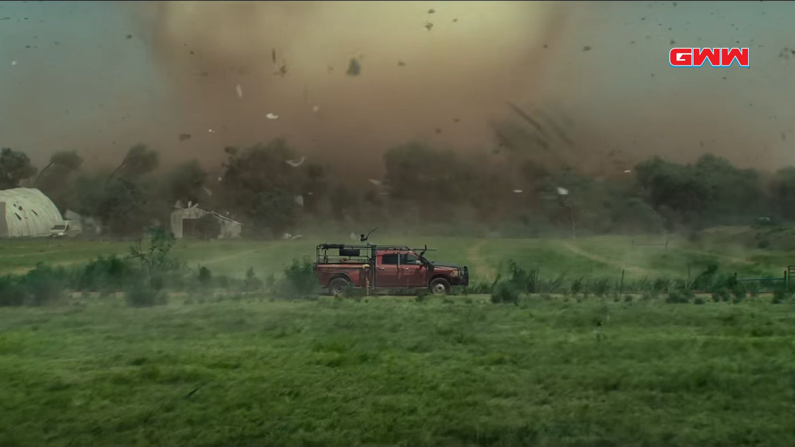 Un coche estacionado en un campo con un tornado amenazante, película Twisters