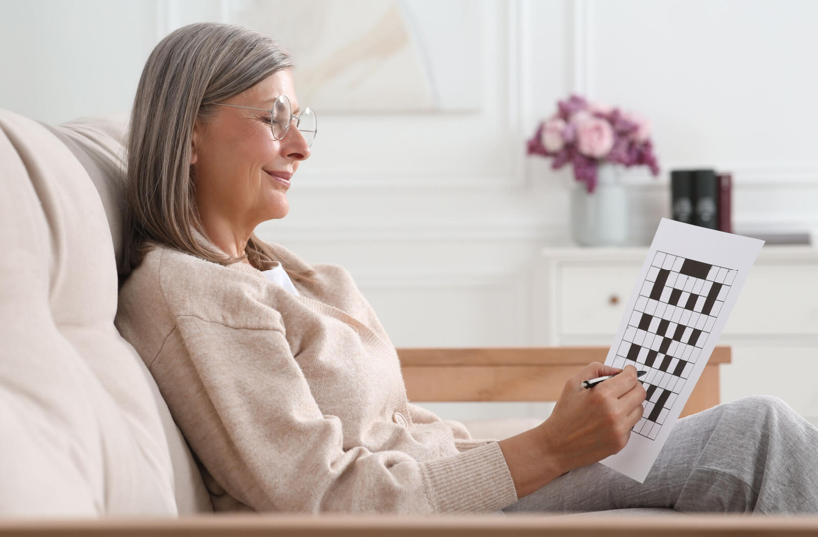 An older adult woman solving a crossword puzzle