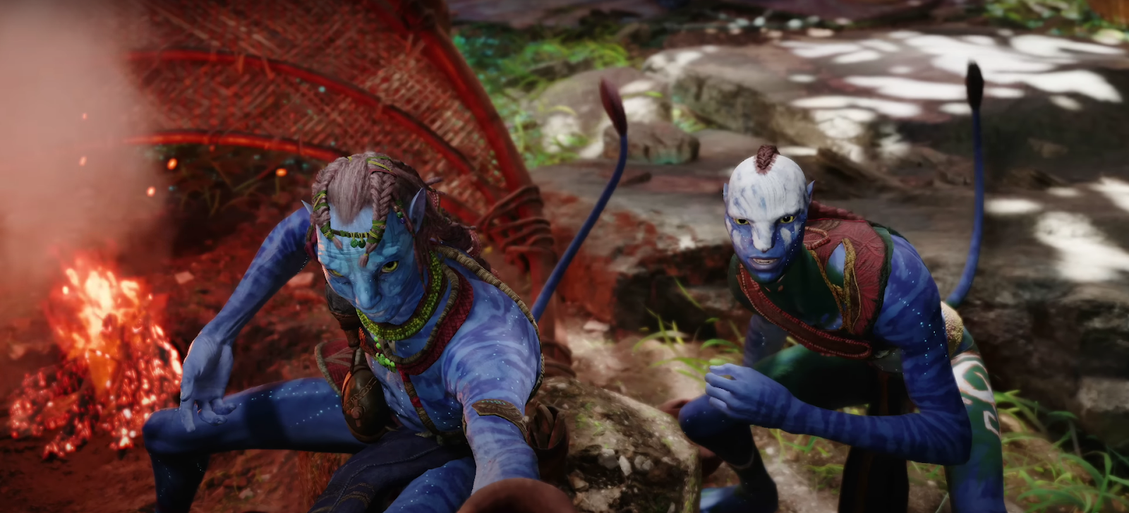 Two Na'vi crouching by a fire in Avatar: Frontiers of Pandora