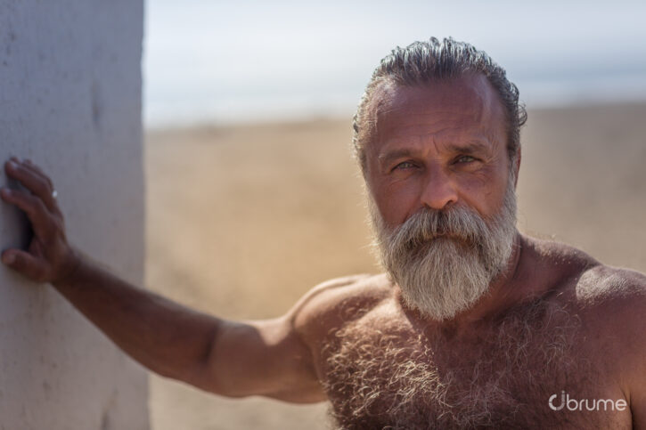 Daddy John taking a shirtless photo outside in the desert