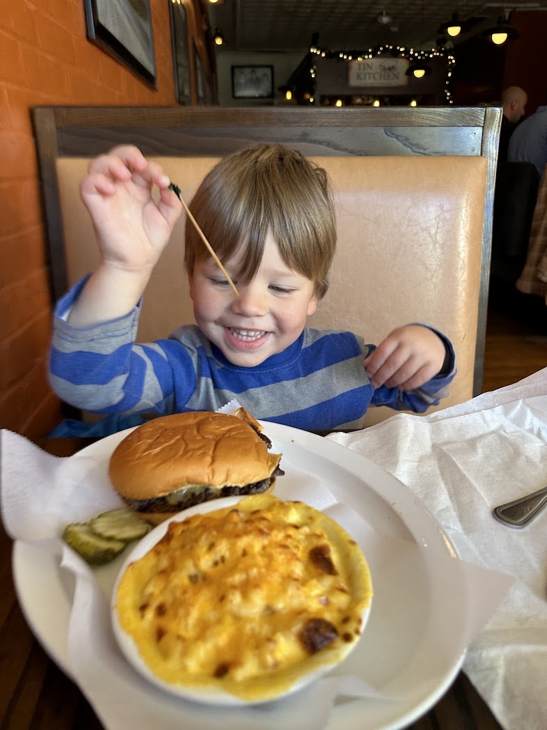 A boy smiling about his meal at the Tin Kitchen
