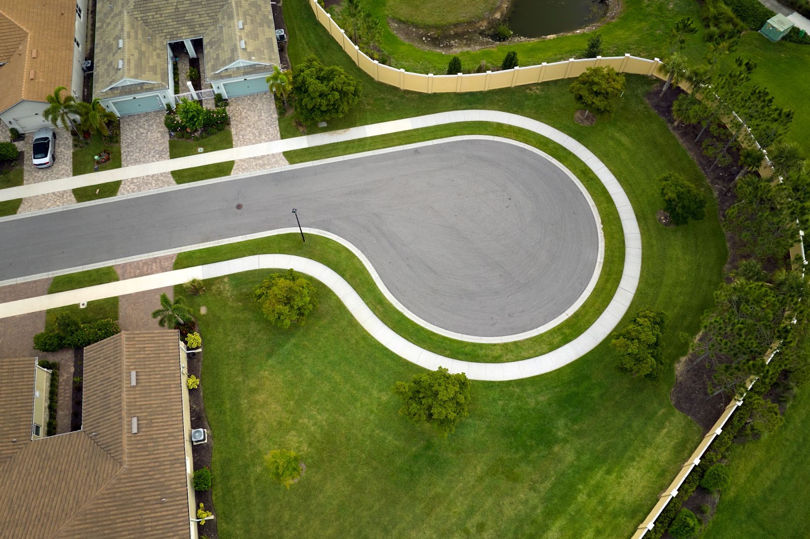 Aerial view of a concrete cul-de-sac at a neighborhood street dead end, showing tightly packed homes arranged in a close-knit community layout.