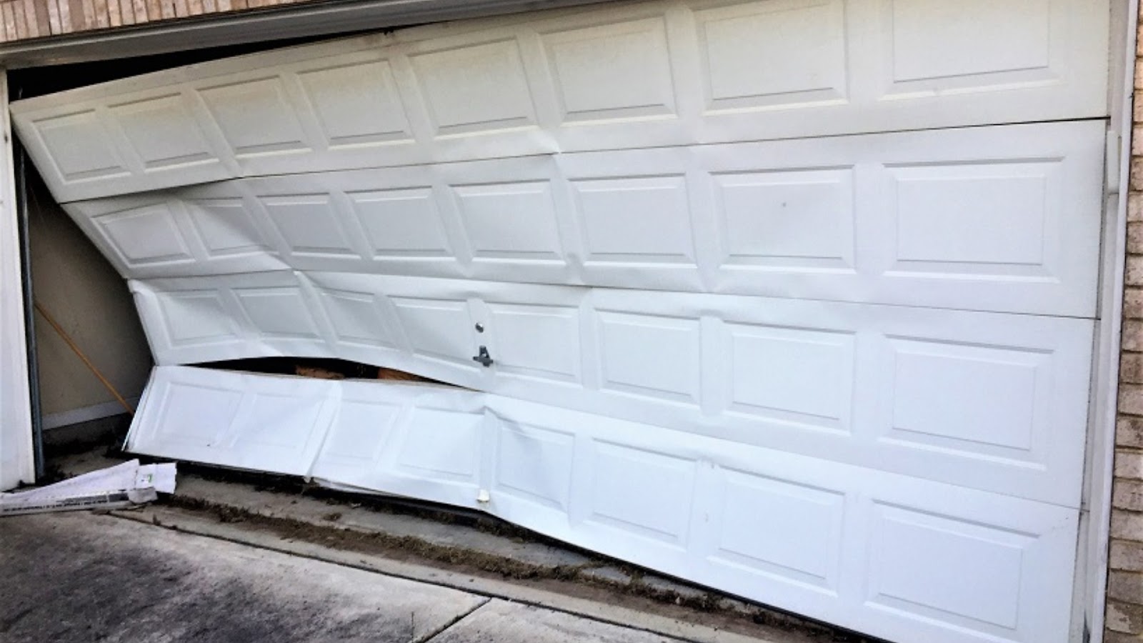 A broken door being prepared for garage door panel replacement