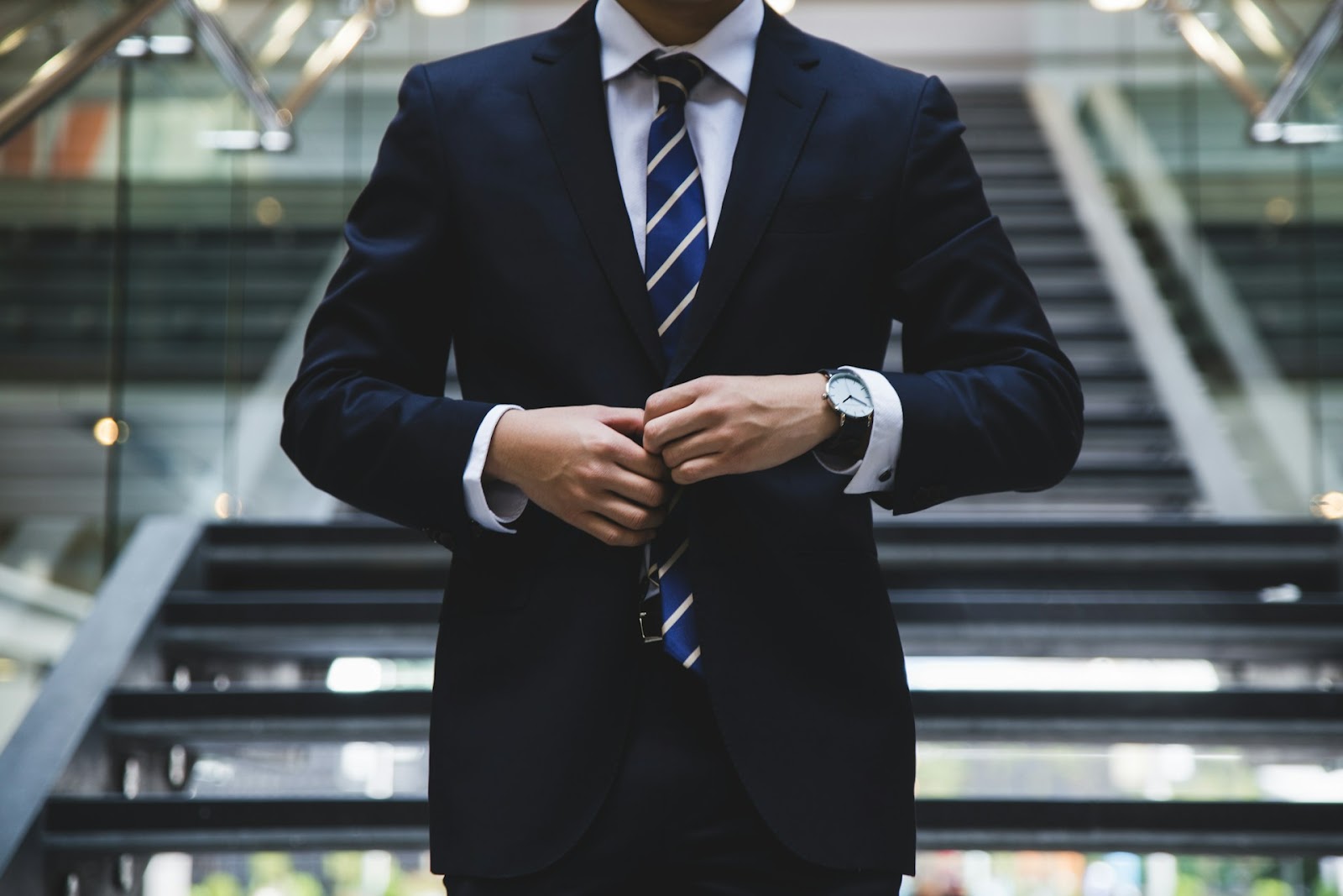 A man in a suit fixing his coat