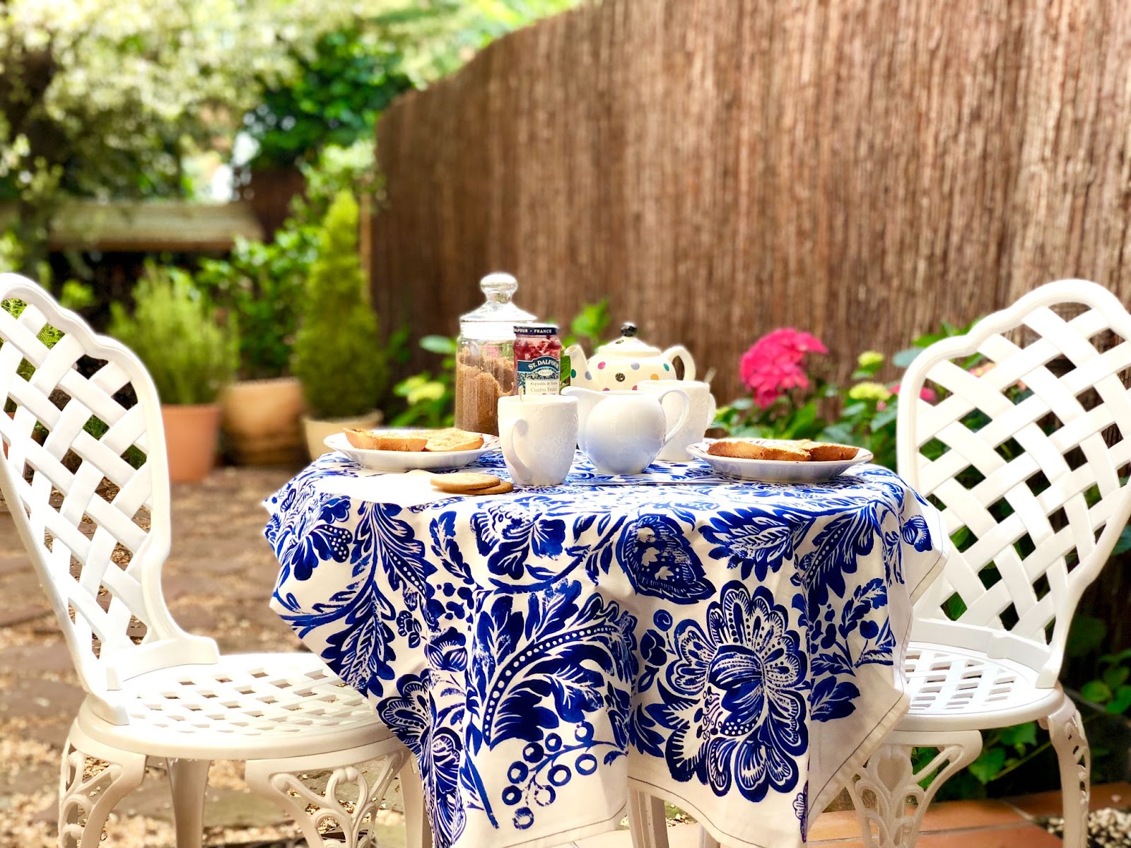 Runder Gartentisch zum Frühstück für Pärchen gedeckt mit Tischdecke
