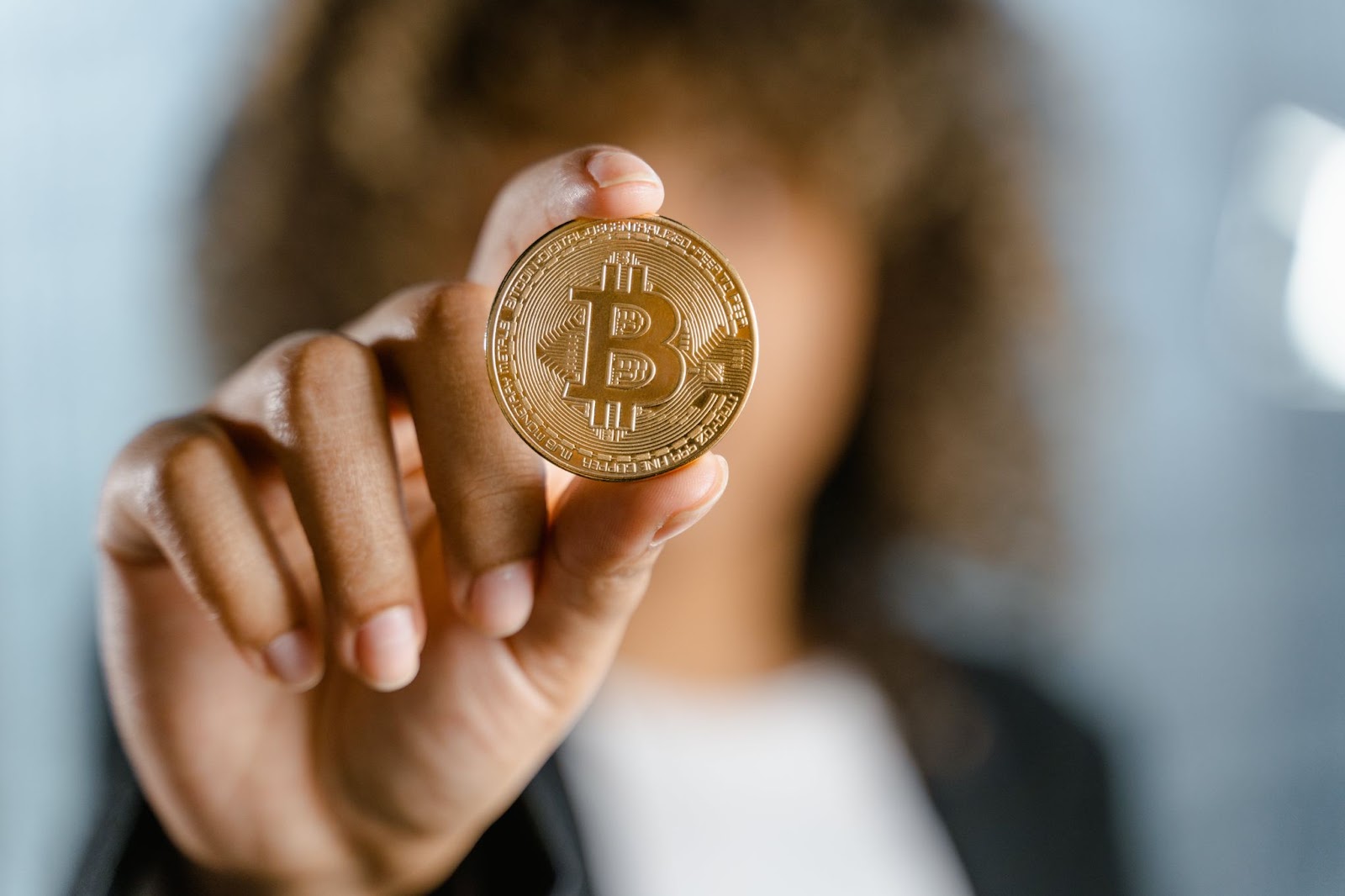 Bitcoin in the hand of a women showing it to the camera