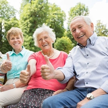 Senior citizens and adults giving thumbs up and smiling to the camera